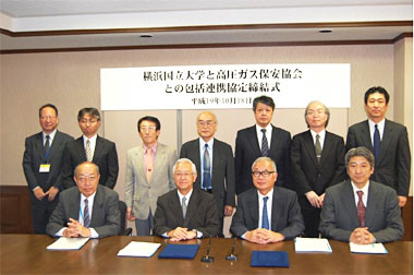 写真:関係者による記念撮影
(一列目右から、KHK伊藤理事、作田会長、横国大 飯田学長、渡辺副学長。二列目右からKHK栗原総合企画部長、難波液化石油ガス研究所長、竹花高圧ガス保安研究所長、横国大 関根教授兼安心・安全の科学研究教育センター長、小林教授、小林准教授、中村産学連携課副課長)